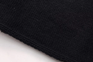 Close-up of black fine knit fabric texture with natural rolled edge detail