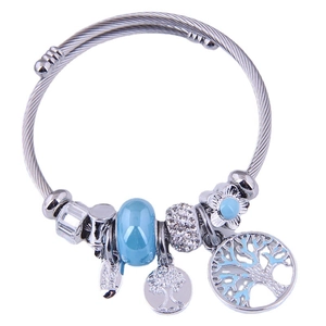 Silver twisted bangle featuring tree of life charms and blue crystal beads on white background