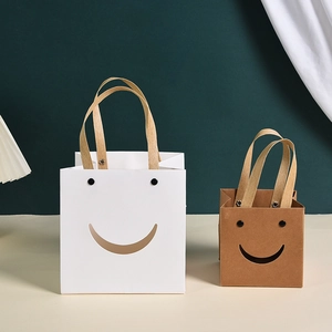 Creative smiley face paper gift bag with silk ribbon handles in white and kraft colors