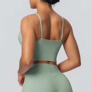 Détail du haut de yoga vert sauge montrant les fines bretelles et le dos croisé