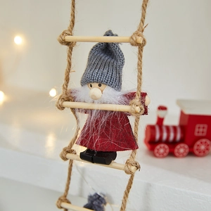 Close-up of a festive gnome on a rope ladder with soft bokeh lights and holiday decor