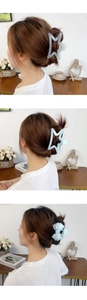 Detail of light blue matte star and bow hair claw clips worn in a stylish hairstyle