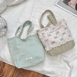 Detailed view of floral lace trim and bow patterns on canvas tote bags for women