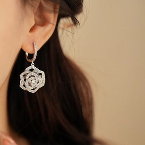 Detailed close-up of a silver flower earring with pave-set sparkling zircon crystals
