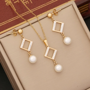 Golden jewelry set with diamond rhombus pendants and pearls in a cream gift box