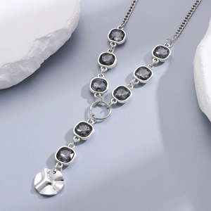 Detail view of silver necklace with black faceted crystals and textured metal pendant