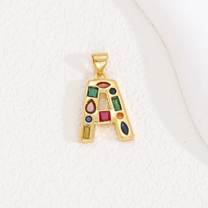 Gold letter A pendant necklace with colorful zircon stones on white textured surface