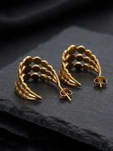 Vue macro de boucles d'oreilles dorées en C avec design à trois rangées de disques