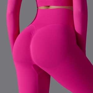 Detailed macro of high-waist scrunch butt seamless leggings in vibrant hot pink fabric