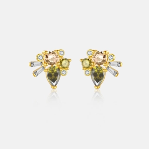 Macro detail of gold plated S925 silver earrings with green pear-shaped zirconia stones