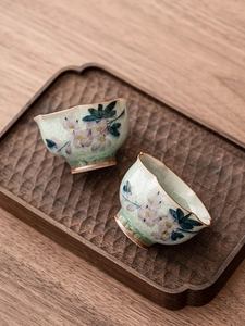 Vue de dessus de deux tasses en céramique avec glaçure craquelée, motifs et bordure dorée