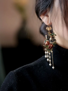 Détail de boucle d'oreille papillon vintage avec pompons en perles sur un modèle