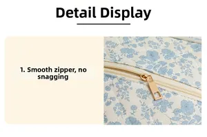 Detail of floral quilted book pouch showing smooth gold metal zipper and stitching