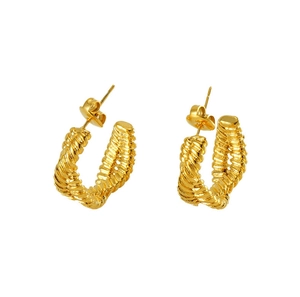 Detailed close-up of golden titanium steel earrings featuring a textured twisted U-shape