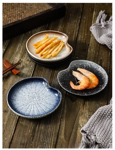 Close-up of irregular ceramic appetizer plates in matte blue and black finishes
