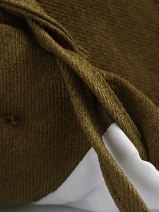 Close-up of olive corduroy fabric texture with soft white inner lining for fashion jacket
