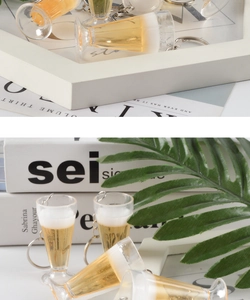 Dettaglio di un portachiavi a tazza di champagne con schiuma e liquido realistici
