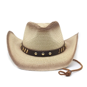 Dettaglio di cappello da cowboy in paglia con borchie metalliche e laccio regolabile