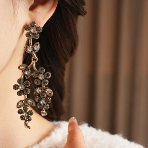 Macro shot of vintage floral tassel earrings with dark grey crystals and silver vine detail