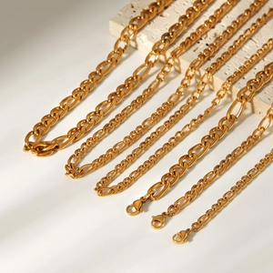 Detailed macro shot of 18K gold plated stainless steel Figaro and curb chain necklaces