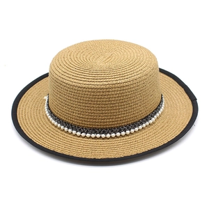 Macro shot of boater hat with black trim and elegant pearl beaded decorative band