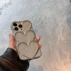 Detail of silver glitter phone case featuring triple 3D heart design and electroplated frame