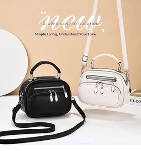 Detail view of multi-zipper leather crossbody bags in black and white with silver hardware