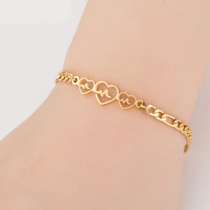 Close-up of golden stainless steel heart bracelet with heartbeat motif on a wrist