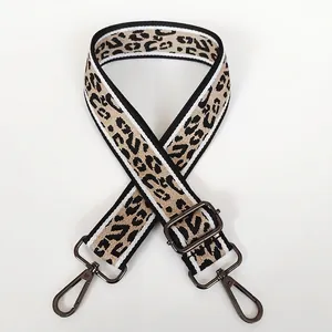 Dettaglio tracolla larga in tela leopardata con ganci rotanti in metallo canna di fucile