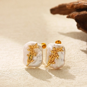 Detail of floral gold-plated accents on baroque pearl earrings for a vintage aesthetic