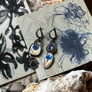 Detail view of retro Egyptian enamel floral earrings with blue gemstones and lever-back hooks