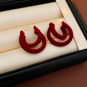 Détail de créoles rouges vintage double épaisseur dans un écrin à bijoux beige