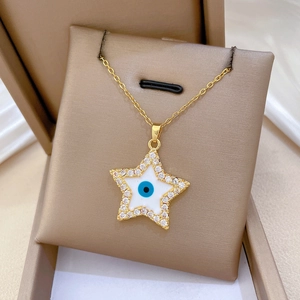 Close-up of golden star necklace with blue evil eye enamel and cubic zirconia in a gift box