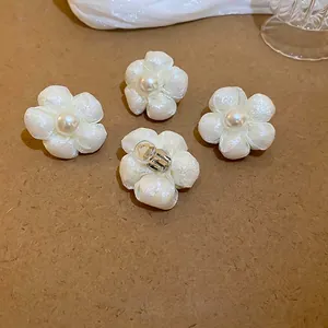 Elegant white camellia flower stud earrings with faux pearls and silver metal clip-on base