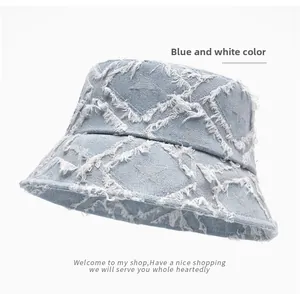 Detail of star-patterned denim bucket hat showing frayed edges and washed blue texture