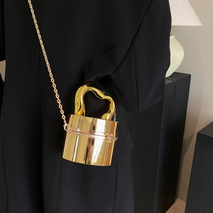 Golden acrylic cylinder clutch bag with twisted metal handle and stylish chain strap