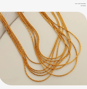 Detail view of multi-layered golden snake chain with polished texture and elegant drape
