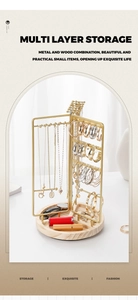 Rotating jewelry stand with gold metal hooks and light wood base for tiered storage