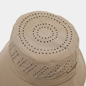 Detail of outdoor sun hat with laser-cut ventilation holes and grid texture fabric