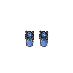 Vintage style floral earrings with blue gemstones and bronze metal on a white background
