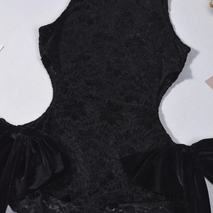 Close-up of black lace bodysuit featuring large velvet bow accents and intricate floral patterns