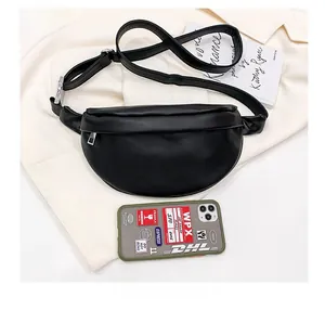 Size comparison of the black half-moon waist bag next to a smartphone on white fabric
