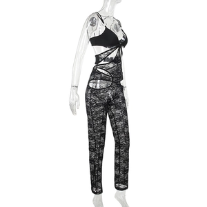 Detail of sheer black lace bodysuit with intricate geometric cut-outs and mesh texture