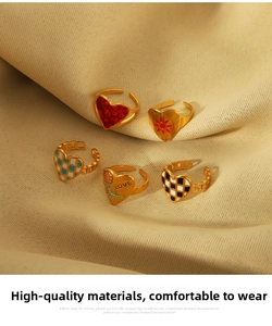 Macro detail of a 5-piece gold-plated heart ring set with colorful floral enamel designs