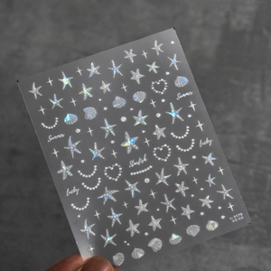Detailed view of iridescent sea-themed nail art stickers with starfish and shells