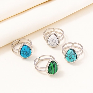 Set of four adjustable silver rings with pear-shaped stones in textured frames