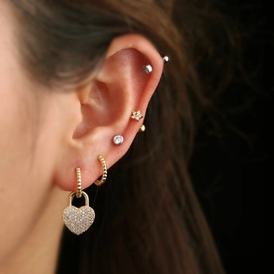 Polished heart lock earring with zircon inlay and stacked gold hoops set on ear
