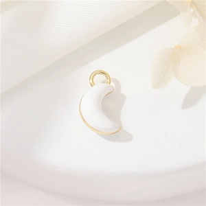 DIY golden crescent moon pendant with white enamel on elegant textured fabric background