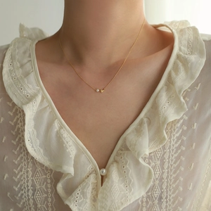 Élégant collier queue de dauphin plaqué or 18 carats avec perle d'eau douce sur modèle