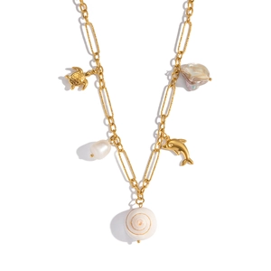 Détail du collier coquillage doré avec breloques dauphin, tortue et perle baroque